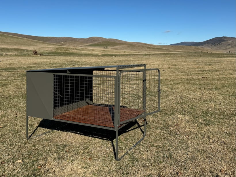 A steel framed Stock Dog Kennels Single Bay Raised dog kennel with mesh walls and a merbau deck floor sits grass.